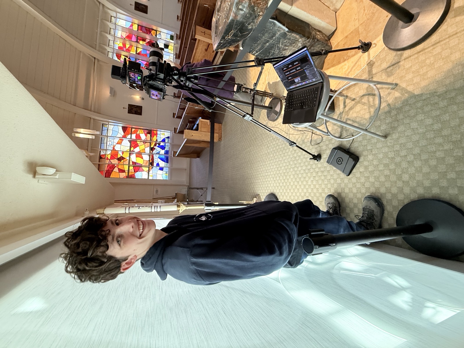 Student volunteer operating a camera at the altar
